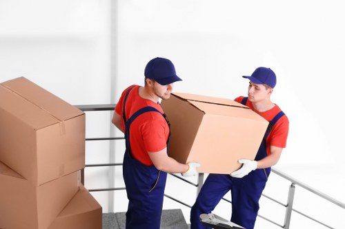 Moving team using safe lifting practices with protective equipment