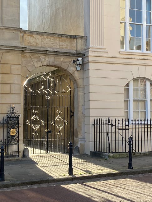 A three-storey building on a corner of Marylebone High Street, with a grey facade and large windows on the upper floors. The ground floor features a storefront with striped awnings and potted plants o