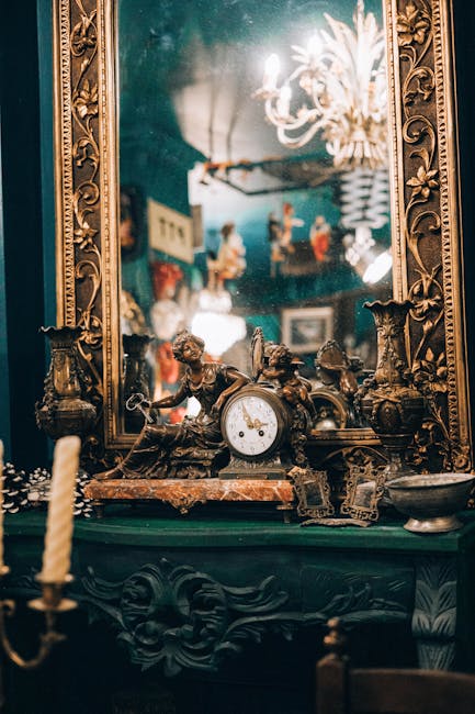 A vintage setting featuring an antique radio with a curved wooden frame and a glass front, placed on a wooden surface alongside a round clock with a white face and black numerals. Behind these objects, there is a framed landscape painting depicting a river scene with trees and mountains, hung on a brick wall. The lighting in the scene appears warm and subdued, highlighting the rustic and nostalgic atmosphere typical of an antique collection or interior. This image reflects the careful handling and packaging of valuable or sentimental items, relevant to house removals and moving services provided by Man with Van Marylebone during furniture transport and packing processes in a home relocation context.